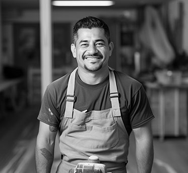 Black and white photo of professional floor sanding worker smiling at the camera