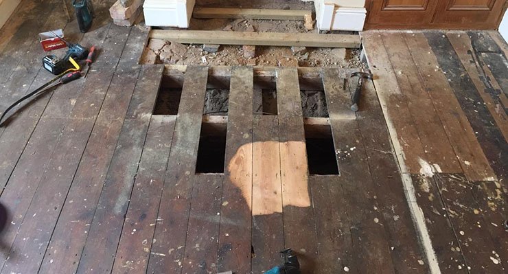 Wooden floor being repaired with several boards already missing