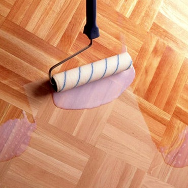 A wooden floor that is currently being varnished